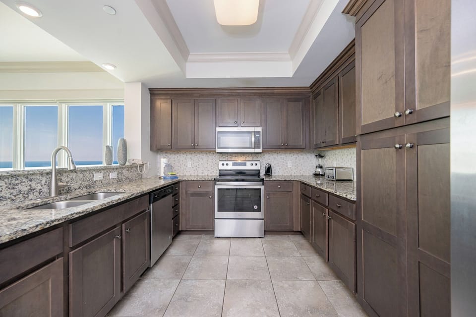 Prepare delightful meals while enjoying natural light streaming through large windows in this inviting kitchen