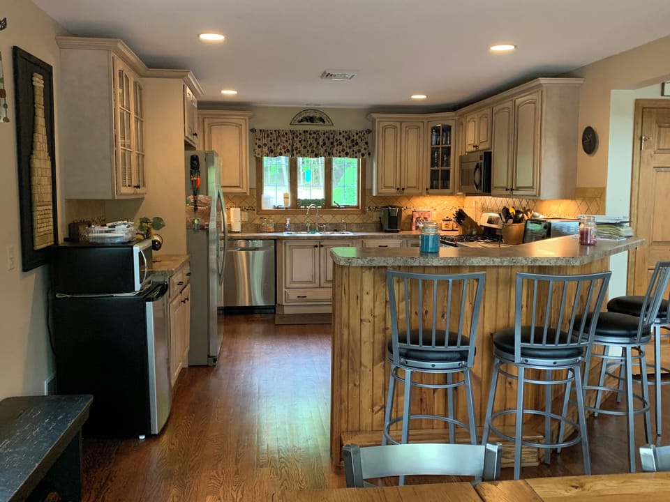 Kitchen with small second fridge and another big fridge in garage