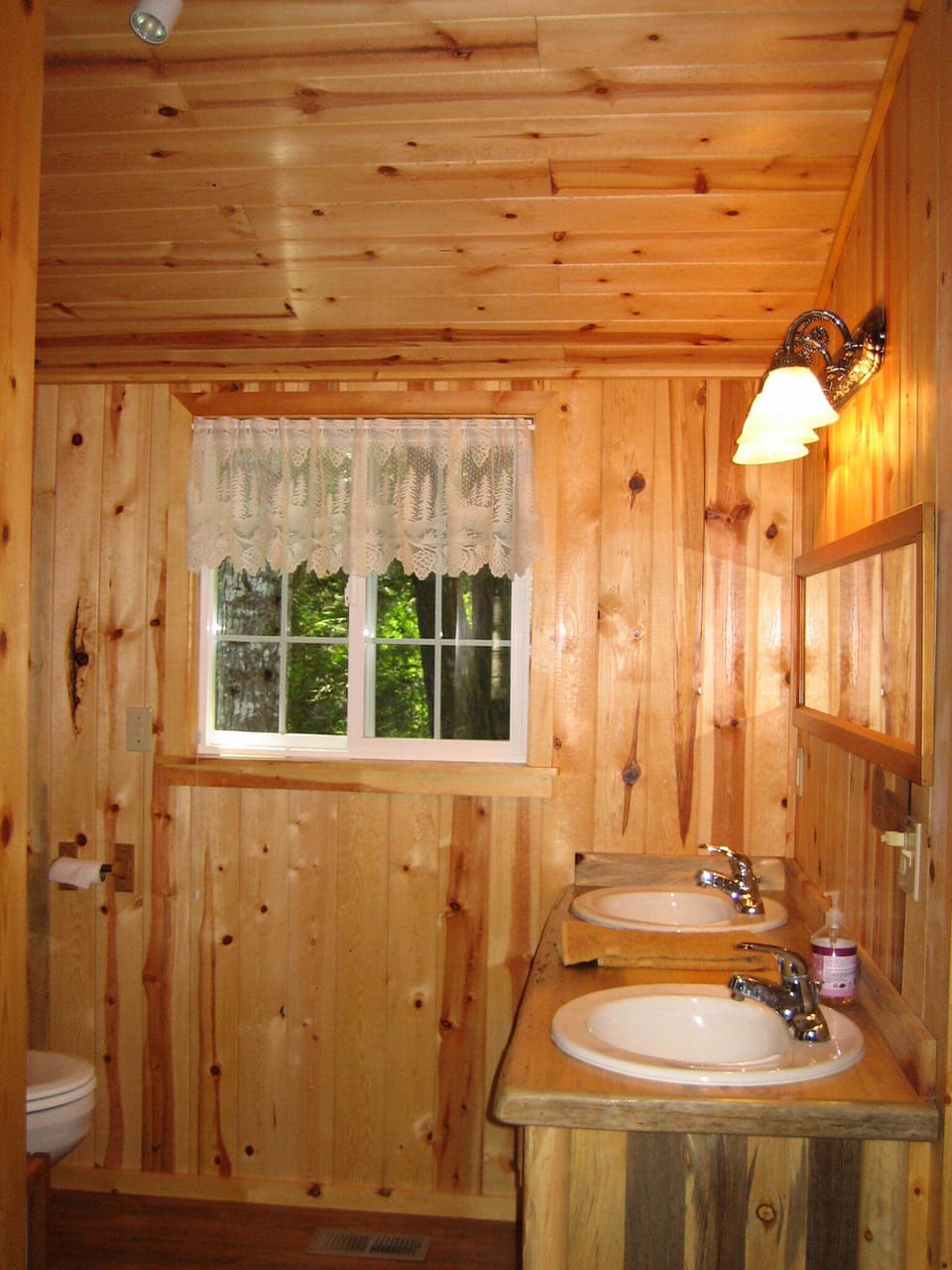 Main bath with knotty pine ceilings, walls + custom cabinets as in rest of cabin