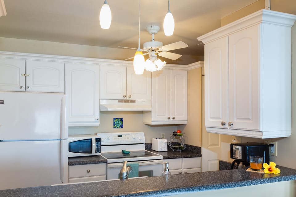 Fully stocked kitchen with microwave, coffee maker, dishwasher, stove, fridge.