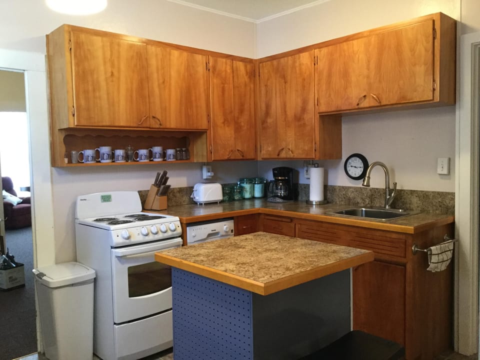 Kitchen with new dishwasher, range, countertops and sink.