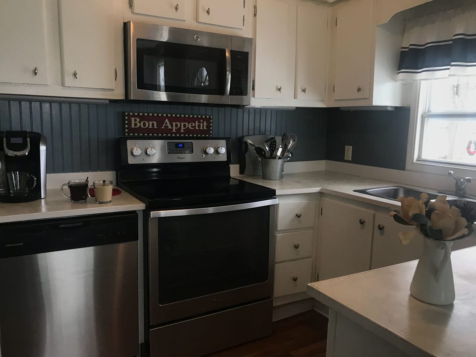 Kitchen with stainless appliances including dishwasher. 