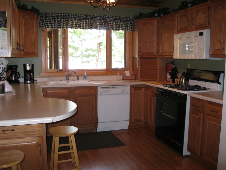 Main level fully stocked kitchen overlooks deck and lake