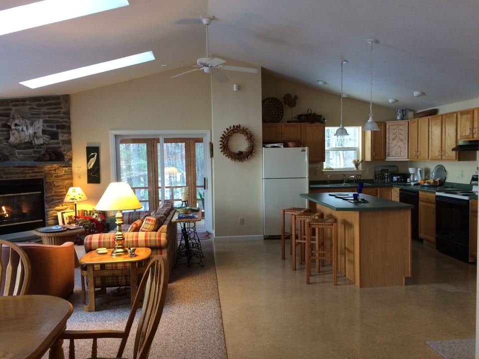 Open-concept combo kitchen, dining and living areas, by screened porch & deck. 