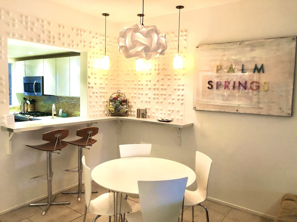 Mid Century dining area with artful light fixtures and modern art on the walls.