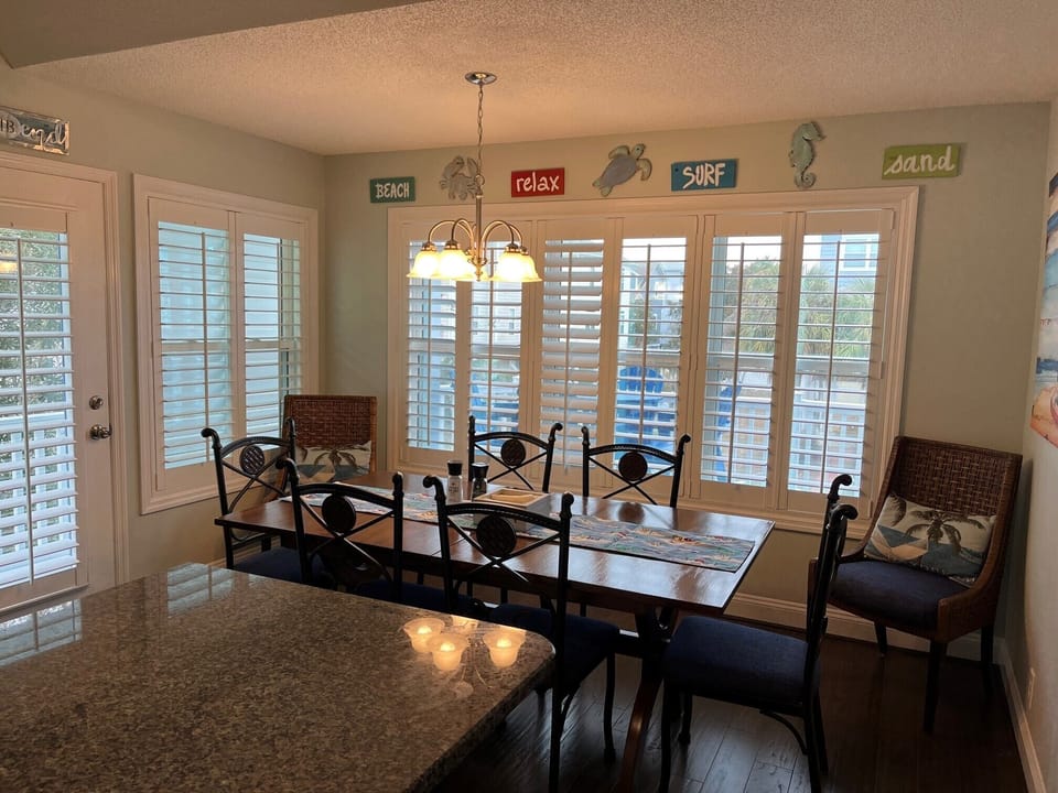 Kitchen dining with 8 chairs and view to the deck.