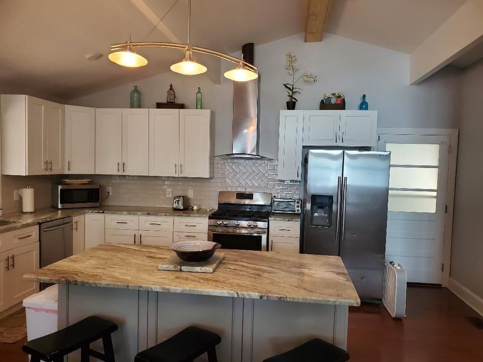 View of the island with seating and the kitchen.