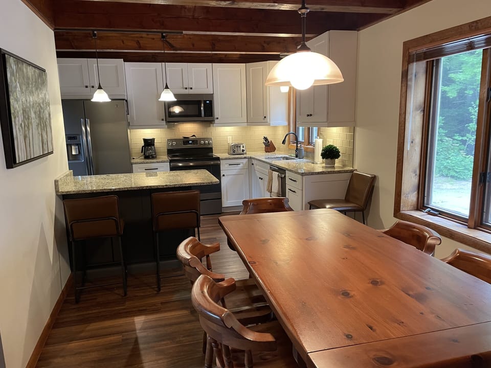 Eat in kitchen with island seating + large dining table.  View from front entry