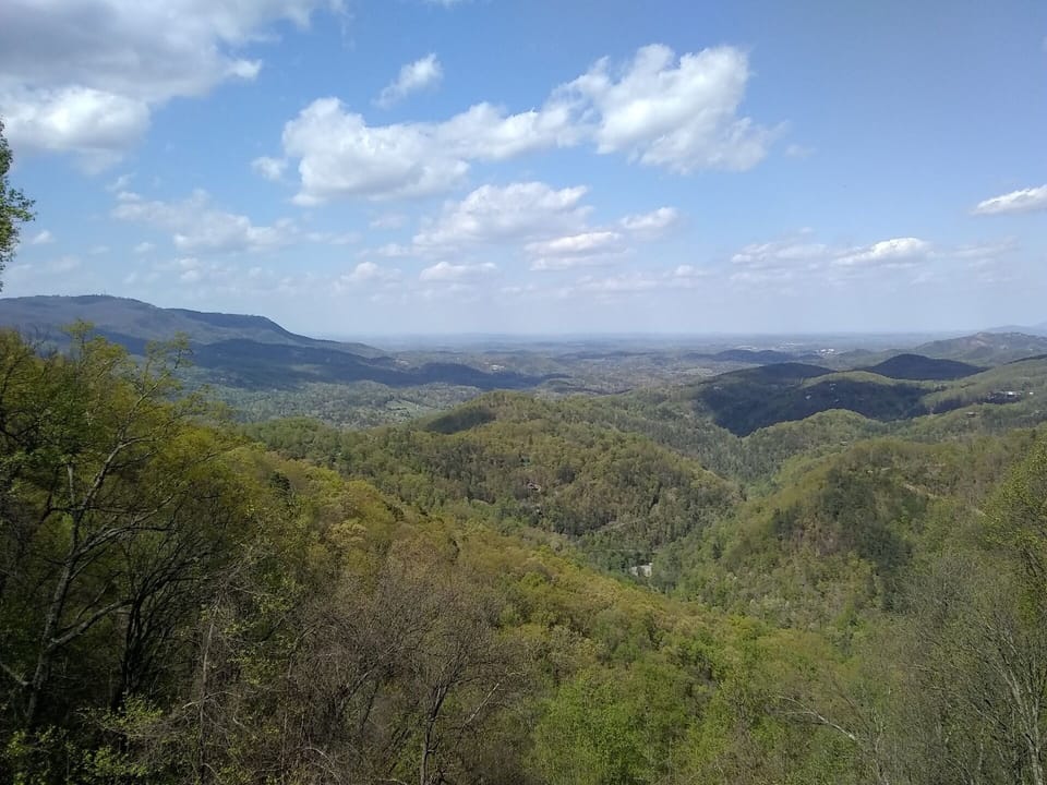 - Expansive Smoky Mountain landscape under bright blue skies   - Endless green ridges stretching into the horizon   - A peaceful reminder of nature’s untouched beauty all around