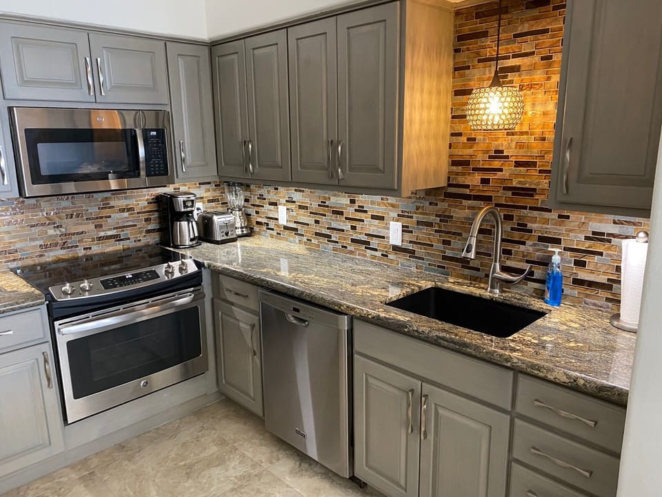 Kitchen has all the pans, spices, fully equipped. Custom glass backsplash.