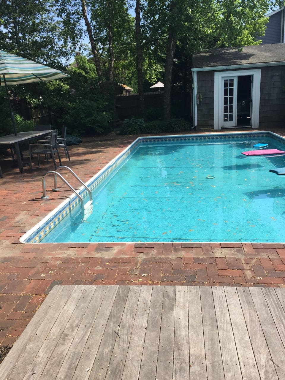 Back patio with pool. Photo taken from back door, showing pool and garage. 
