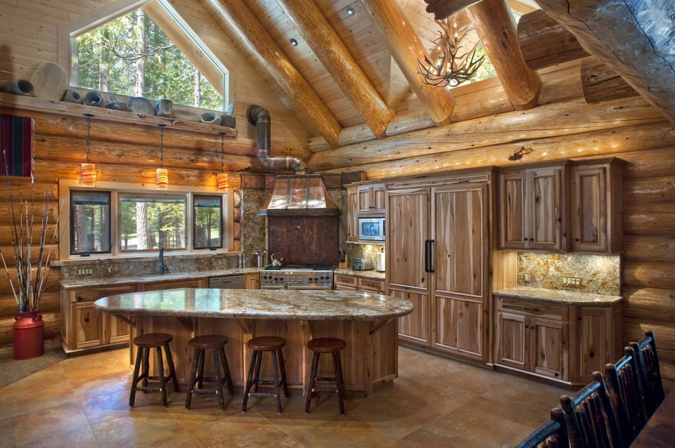 The kitchen boasts a 48" American Gas Range with center griddle and 2 ovens, a sub zero, side by side refrigerator/freezer large enough to accommodate party trays, a dishwasher, and a granite topped serving island