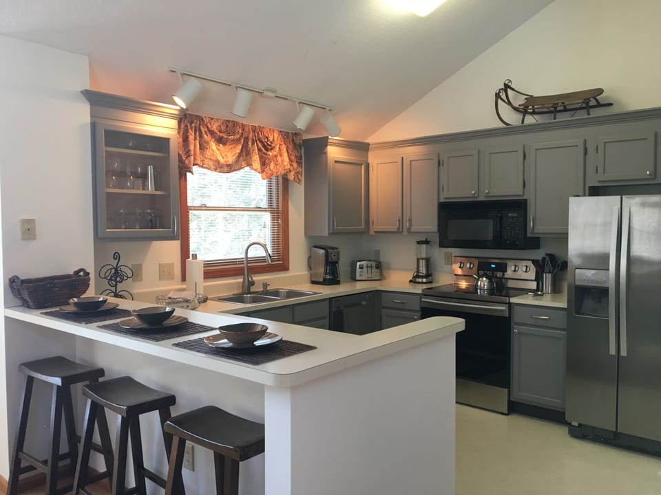 Fully appointed kitchen with three stools at breakfast bar