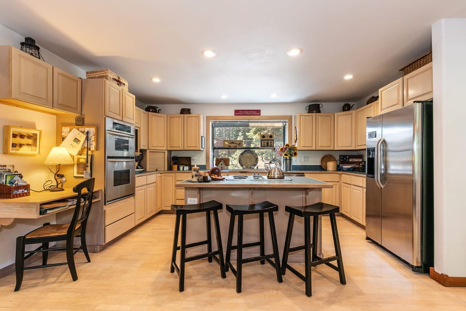 Full size kitchen with center island and newer stainless appliances.