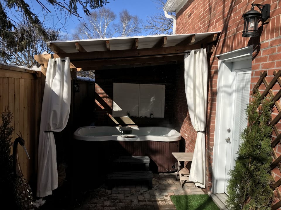 A custom pergola covers the hot tub - privacy curtains too!