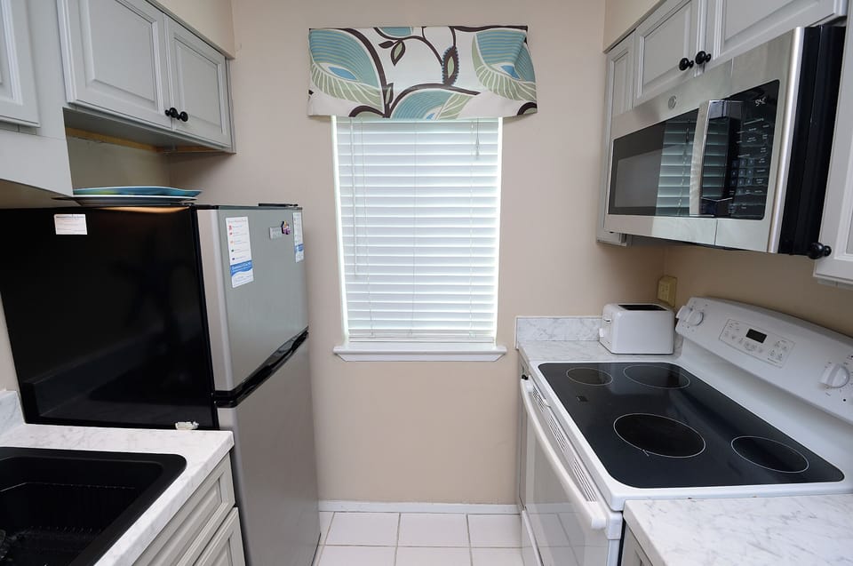 Refrigerator, dishwasher, oven, microwave, coffee maker, cooking items.