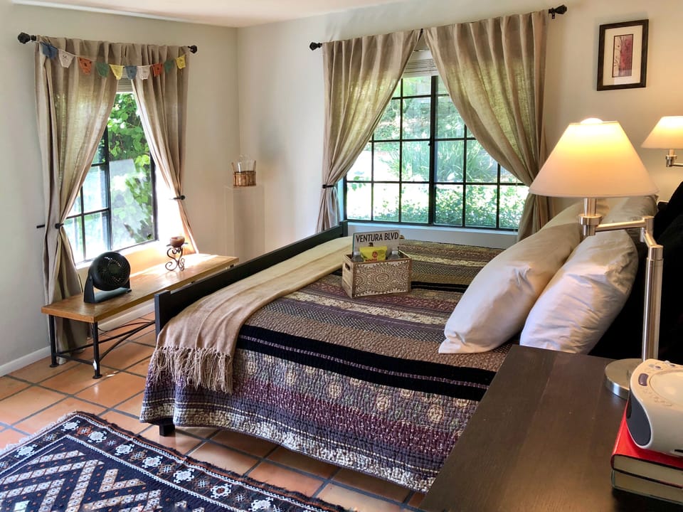 separate bedroom with queen size bed overlooking pool area
