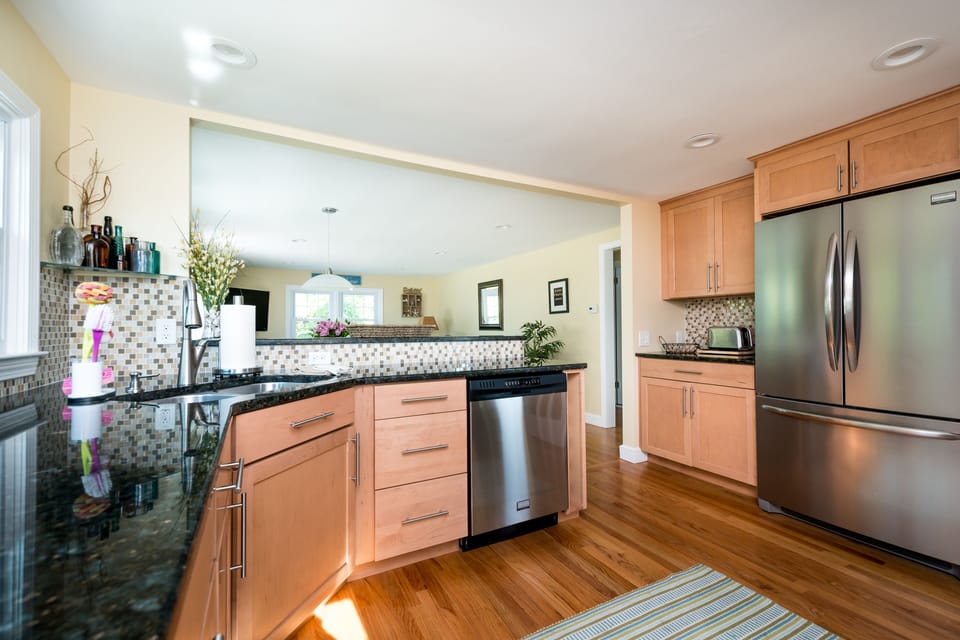 kitchen with all stainless appliances, faces into open family room