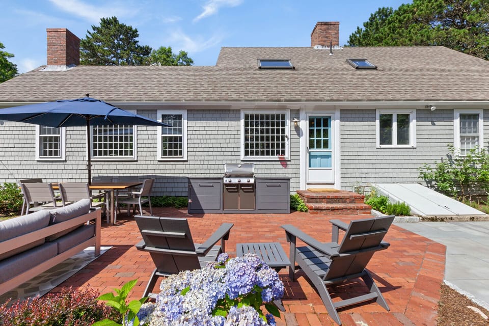 Backyard patio with conversation areas, dining table and grill station