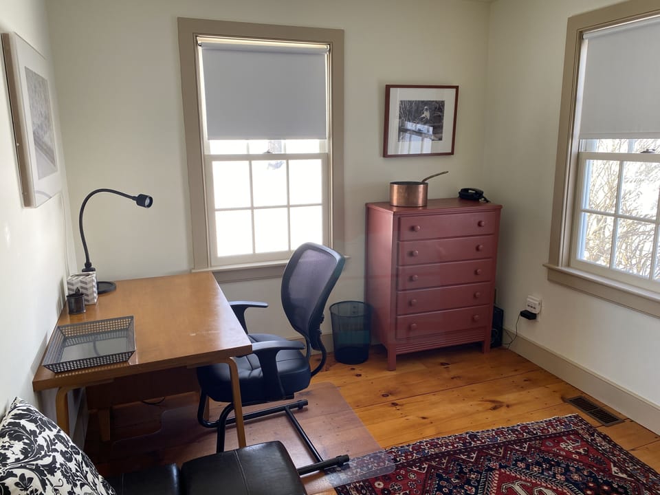 Den/office with desk. Twin sofa bed in foreground can be opened.