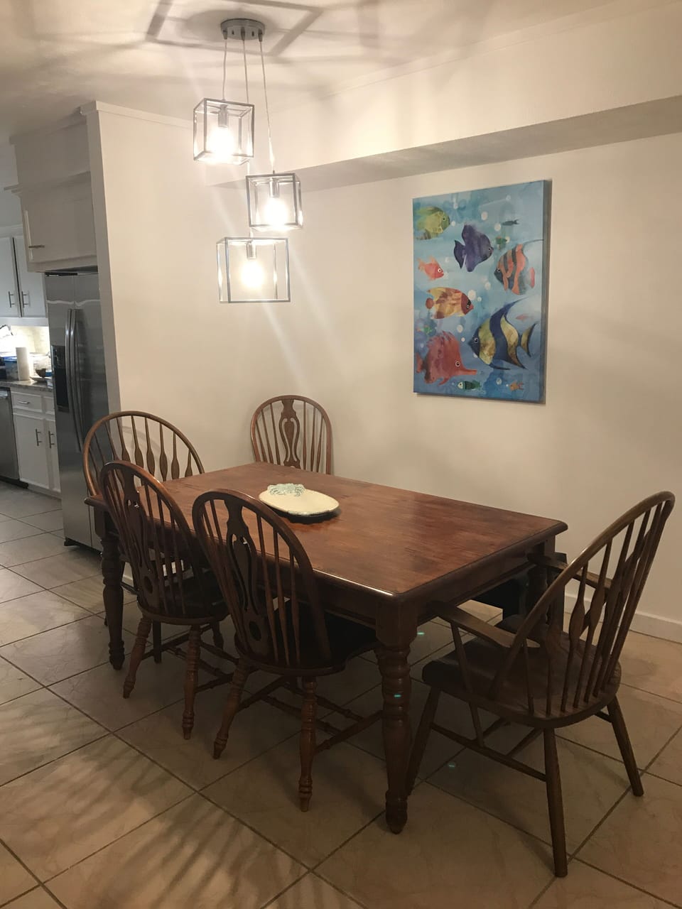 Dining room, with bench behind table. Fun lights and painting. 