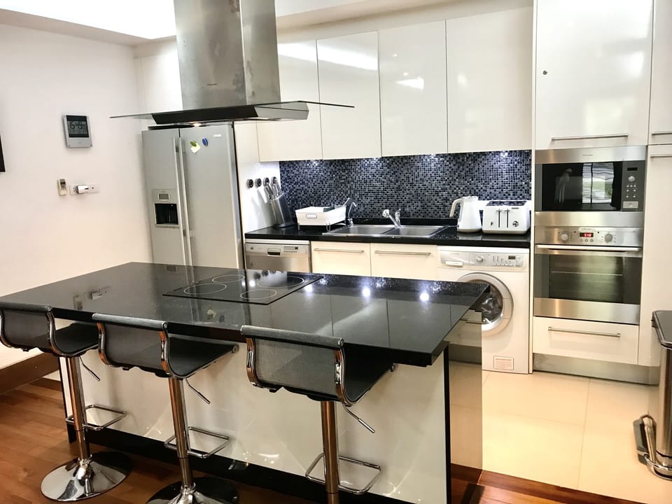 Modern kitchen with breakfast bar and adjustable height chairs.