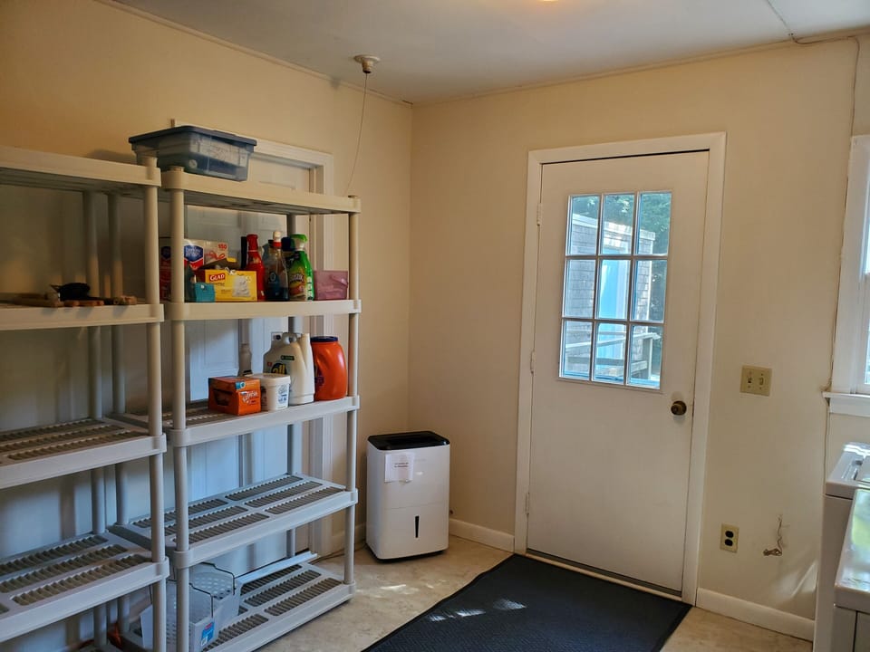 Utility room with washer and dryer and door to deck