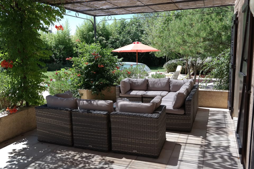 Outdoor sofa on terrace looking towards pool.