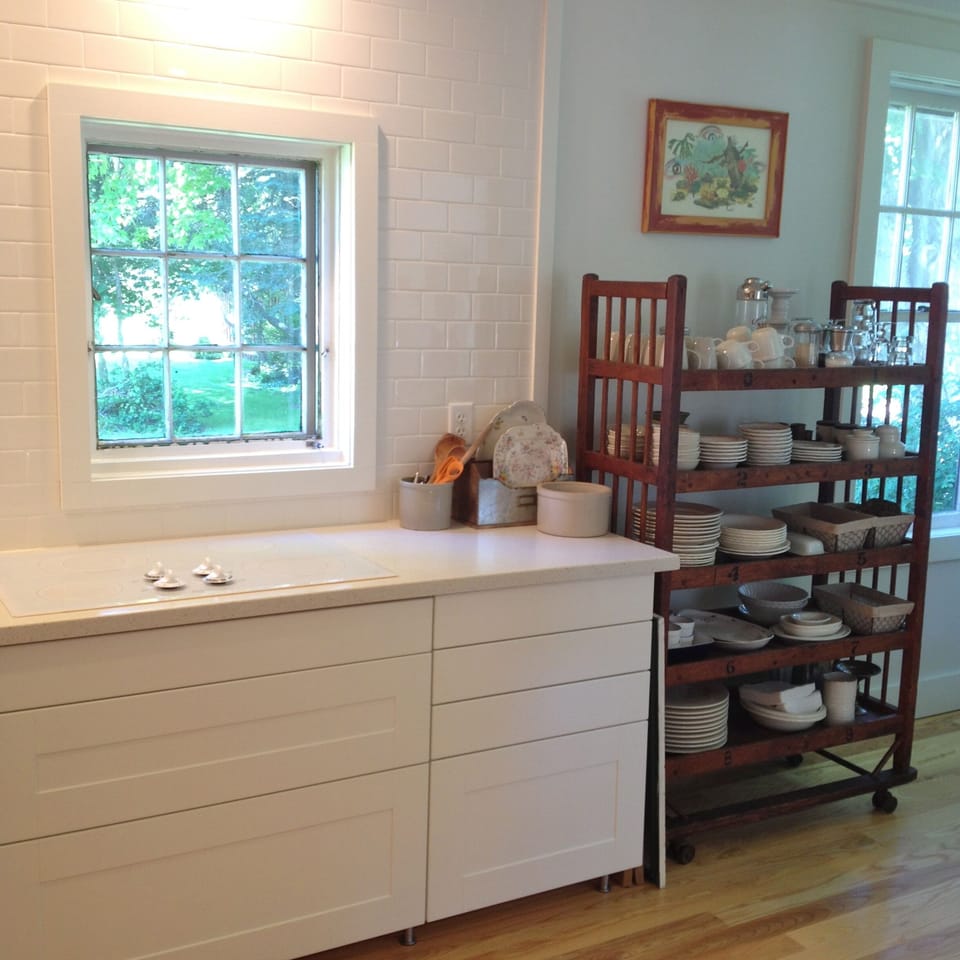 Kitchen with cooktop, window overlooking sunny back yard.