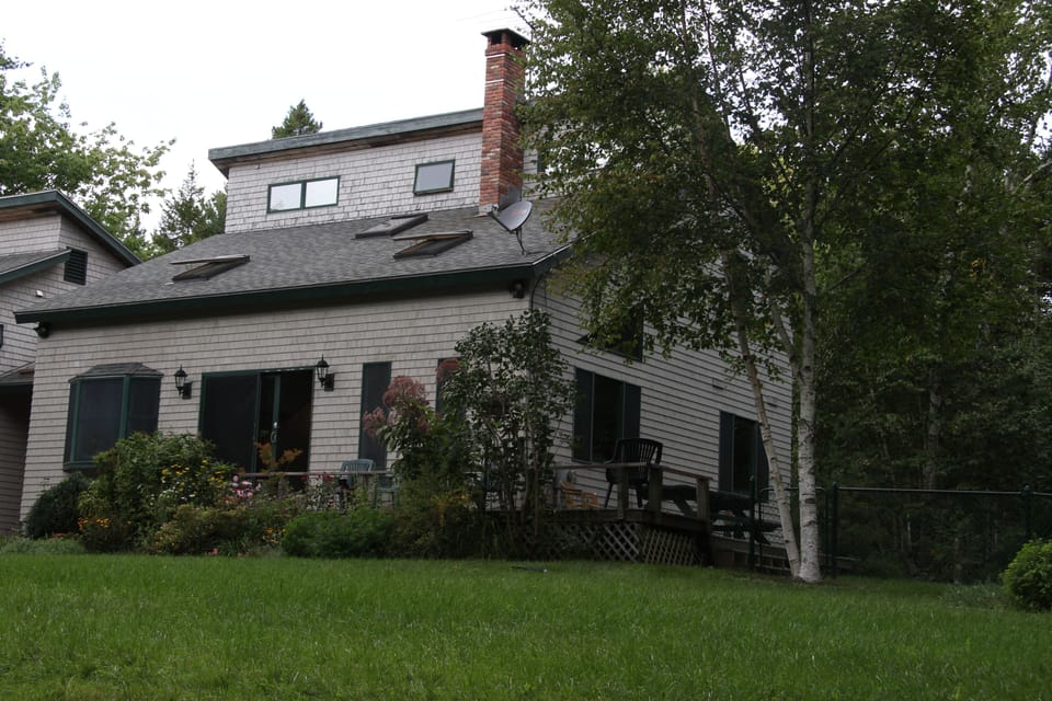 Front has expansive lawn (5,000 sf) and slopes gently down to the woods.