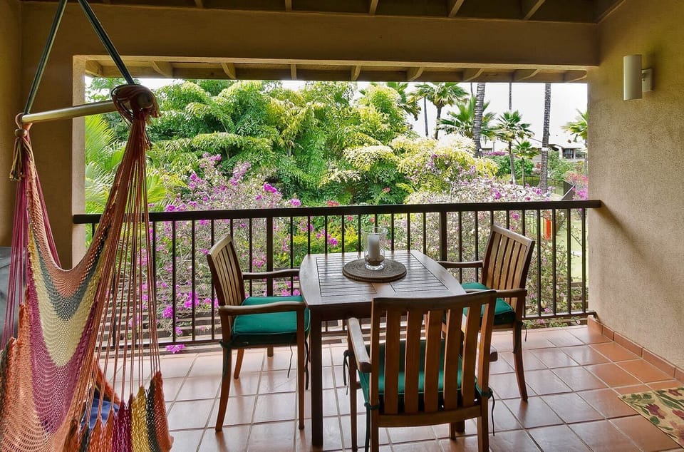 Lanai - looking out to ocean, trees, flowers, with hammock chair