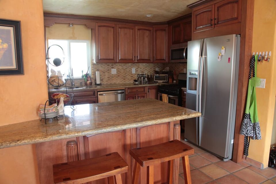 The modern kitchen is fully stocked and opens to the dining room 