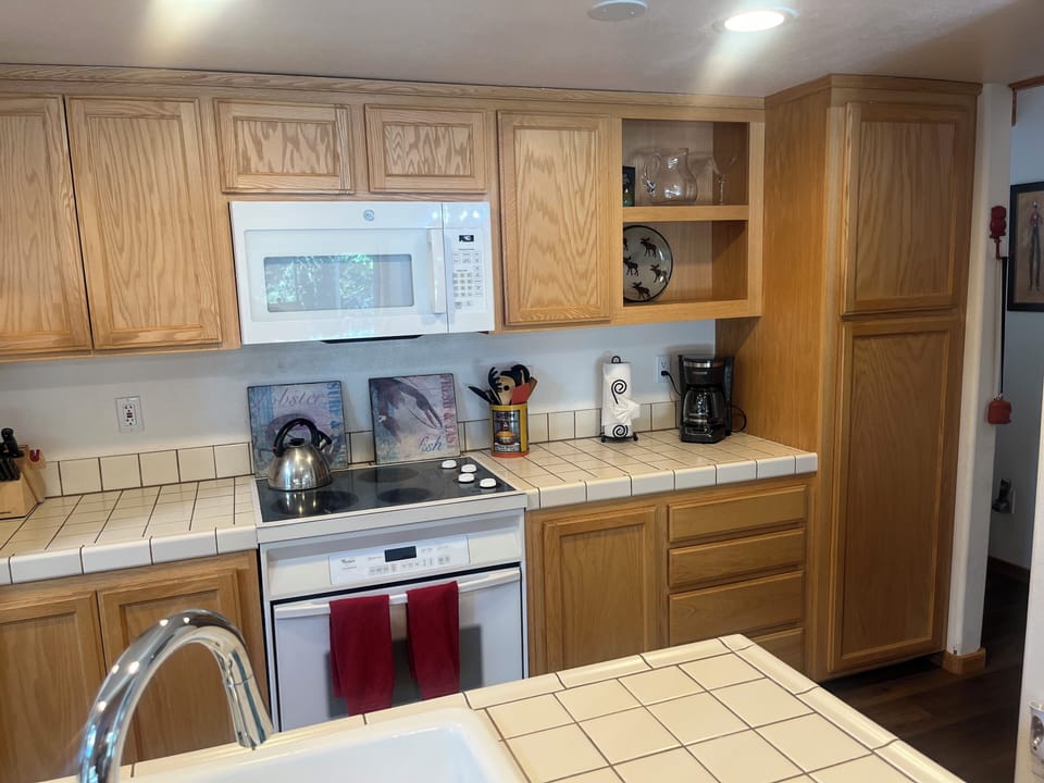 Fully stocked kitchen with dishware, glassware, pots and pans and accessories