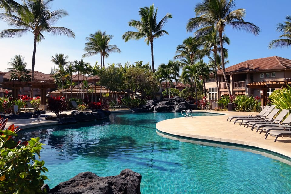 Two inviting pools surrounded with gently swaying palms and lush landscaping