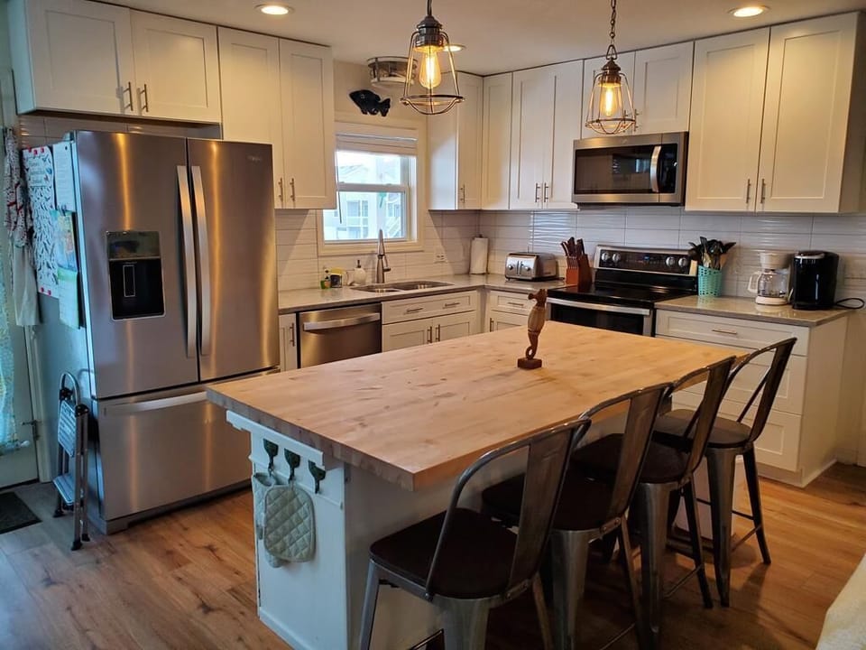 Kitchen with large island stainless steel appliances, plenty of seating