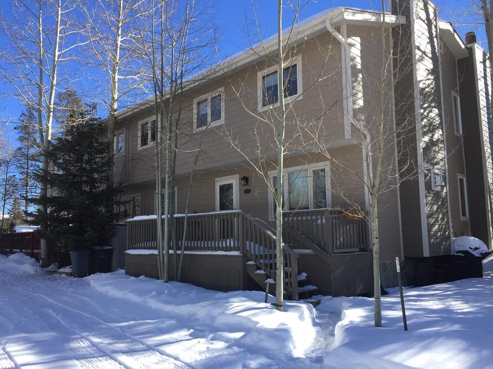 Outside of fourplex.  Our unit is in the back, behind the evergreen.