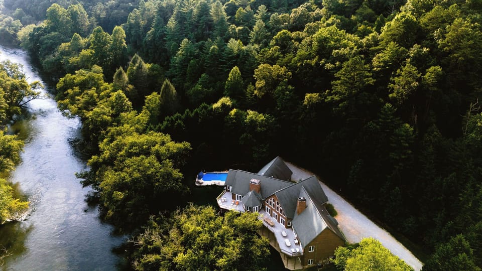 Grand Estate on the Toccoa River! The estate has an amazing yard for games, a pool, hot tub, a play structure, movie theater, bar, and games!