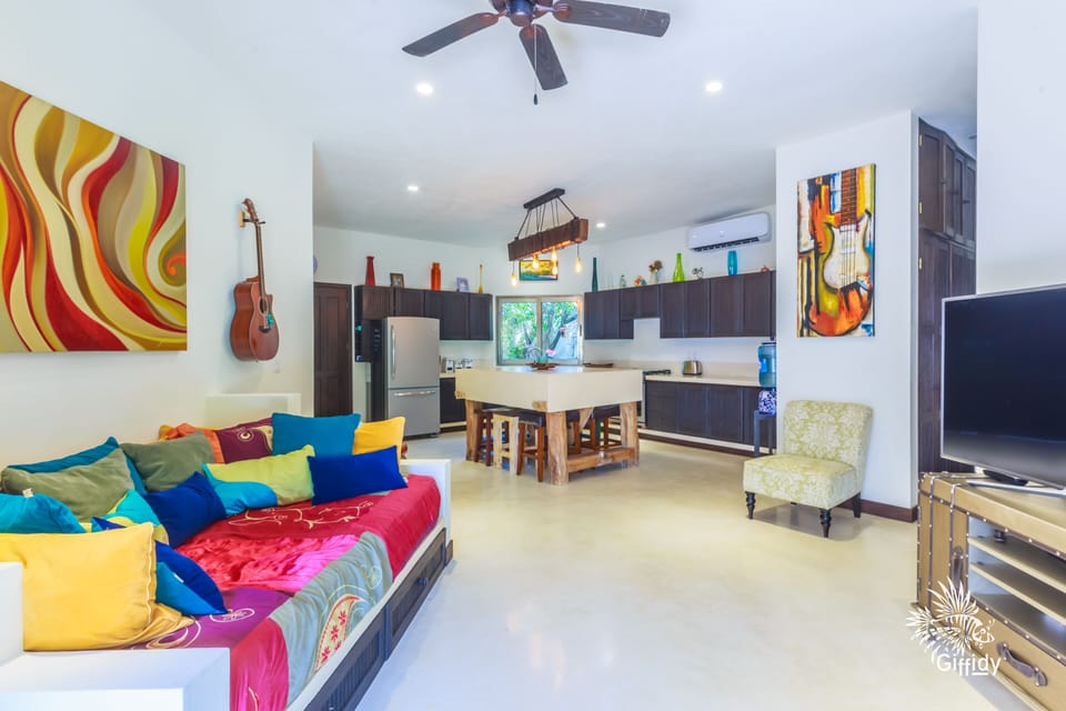 Living area with TV, kitchen with island bar & stools