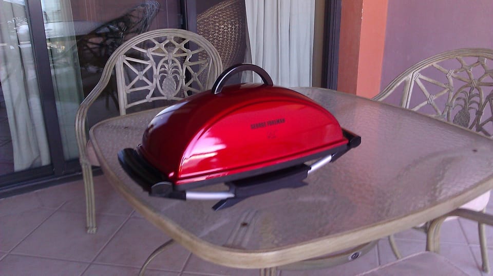 Grill is stored above Refrigerator for grilling on balcony