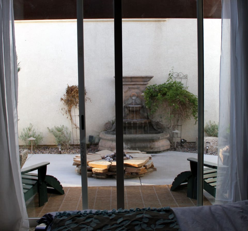 Private patio with gas firepit and fountain as seen from master bedroom
