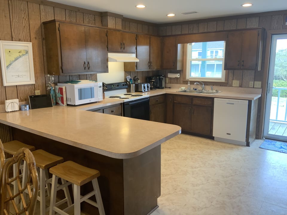 Kitchen equipped with dishwasher, microwave, toaster and coffee maker. 