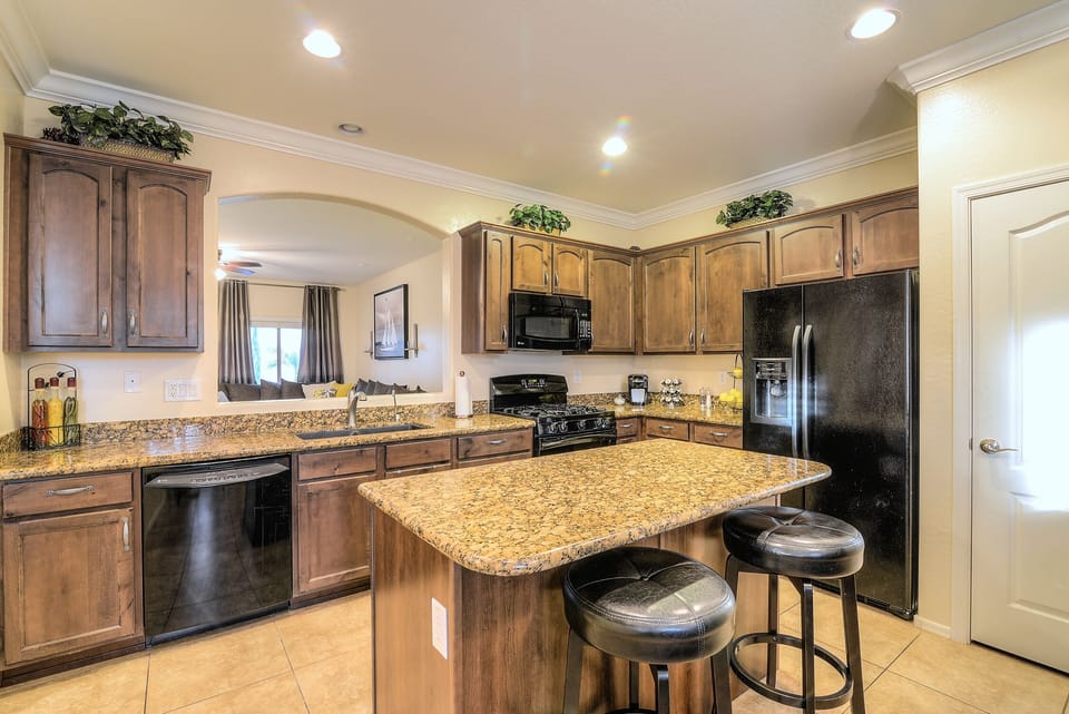 Fully stocked kitchen with granite countertops, island seating & open layout.
