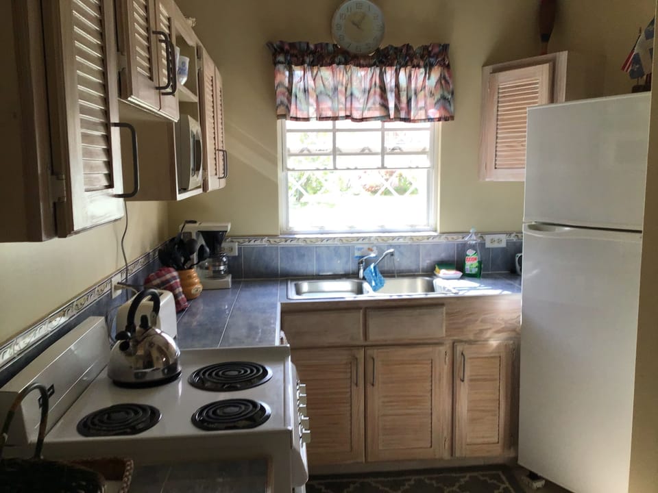 Kitchen with range (oven), micro-wave, coffee maker, refrigerator w/top freezer.