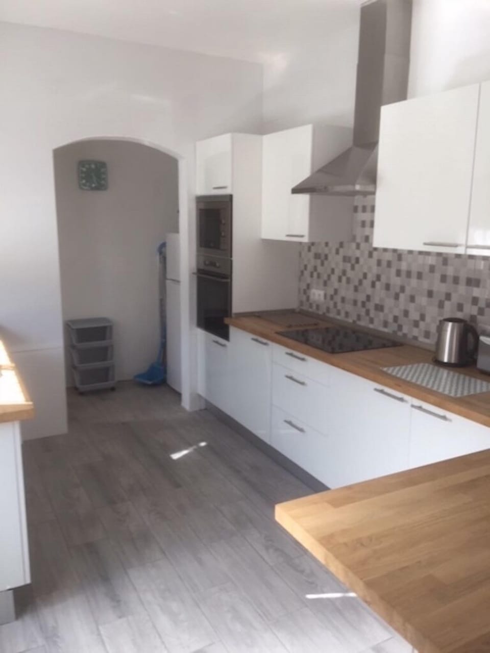 Kitchen divided by breakfast table leads into dining area.