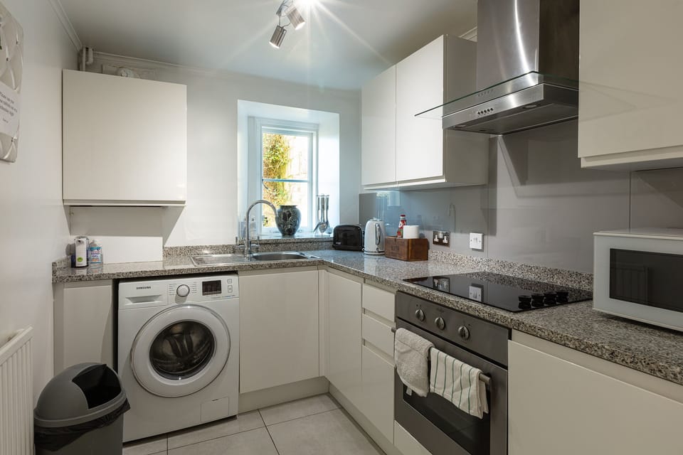 Fully equipped kitchen with washing machine.