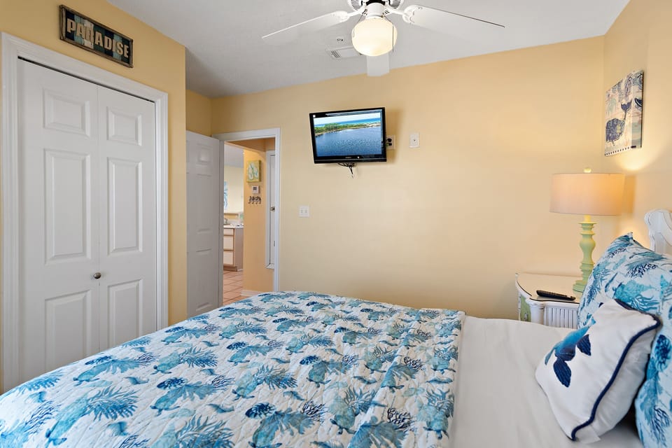 A bright bedroom with a smart TV and cozy bedding.