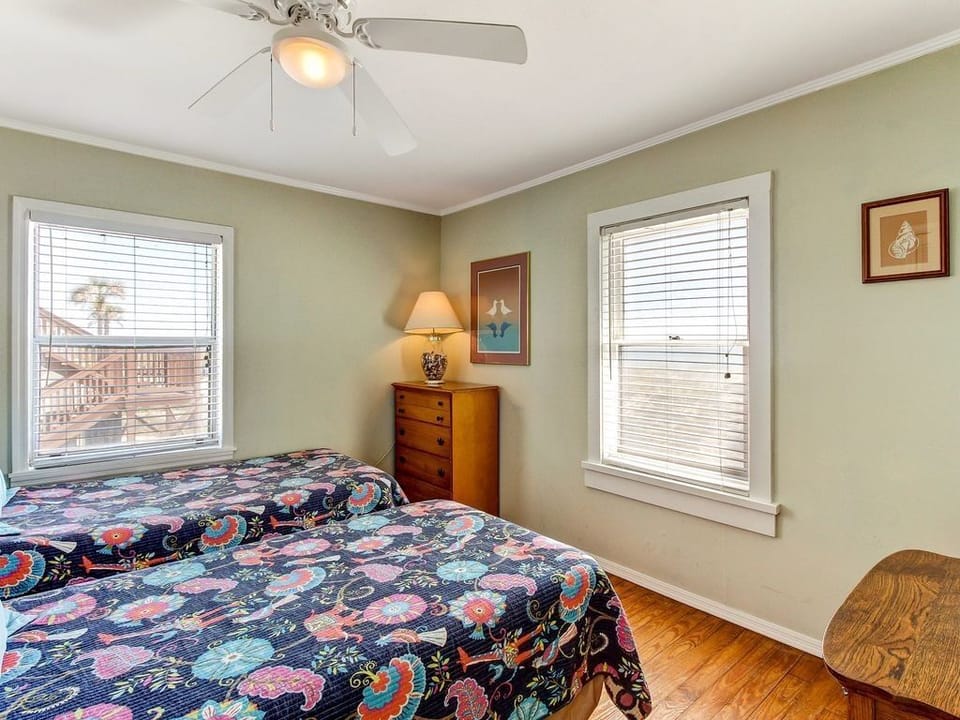 Twin beds with ceiling fan and ocean view