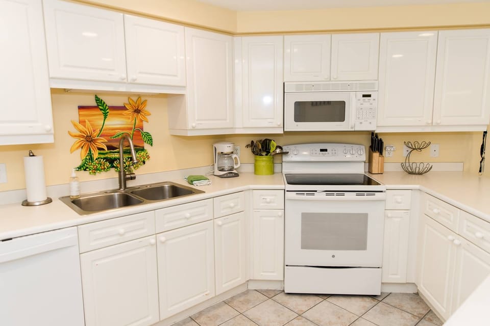 Cabinets are stocked with spices, condiments, baggies and wraps, paper plates. 