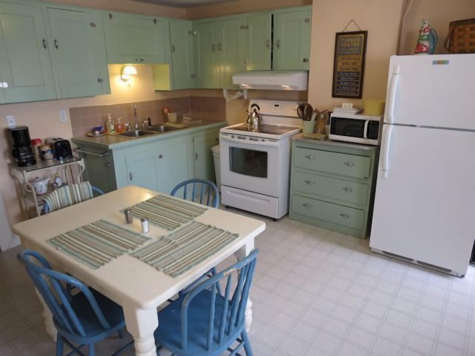 Fully furnished kitchen with tableware and seating for four.