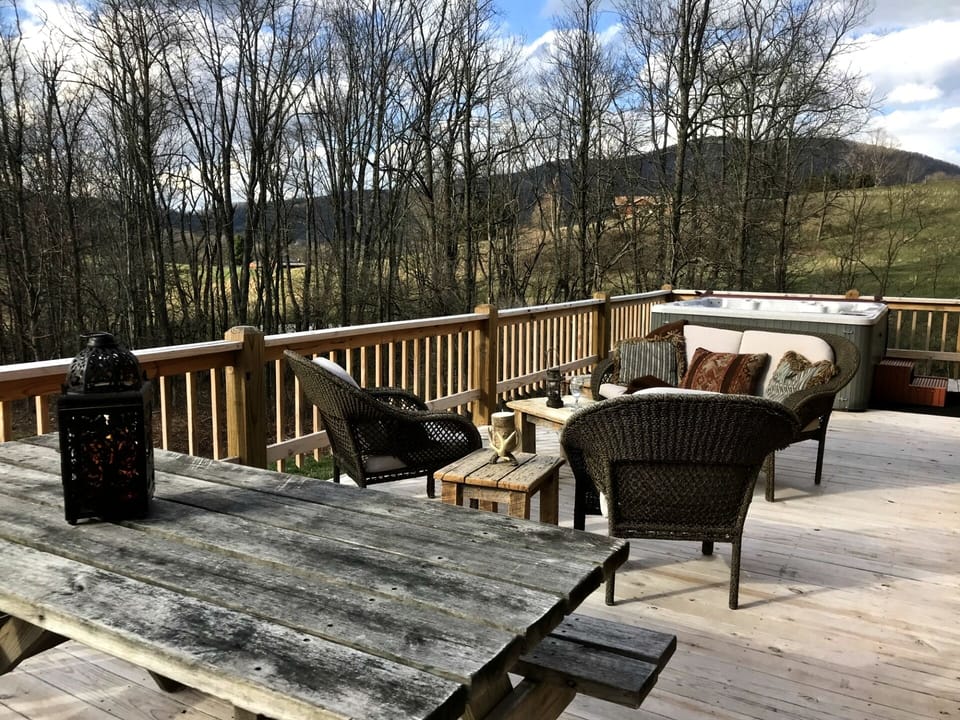 Side porch has a 4 place hot tub and sitting area to watch the sunset & stargaze